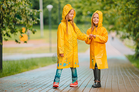 在温暖的春天天雨下 可爱的小女孩孩子夹克公园飞溅季节橡皮水坑下雨预报弹簧图片