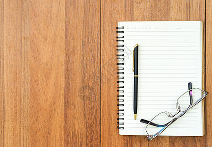 木板上的眼镜和笔记纸教育记事本日记办公室小样奶制品笔记本文档书样机桌子背景图片