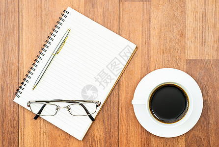 玻璃眼和纸笔 在木板上加咖啡杯记事本办公室咖啡时光眼镜休闲教育日记商业桌子图片