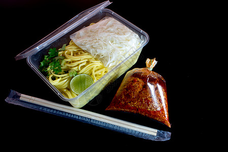 带酱汁的意大利面条用塑料包装将食品带回家美食托盘盒子红色筷子图片