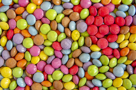 杂货店里展示的多色甜圆糖果的特写小吃绿色涂层白色乐趣橙子黄色圆形棕色童年图片