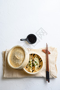 中国小吃 中国蒸饺 中国传统美食 木蒸锅 饺子小吃 亚麻布 白色纹理石桌顶视图图片
