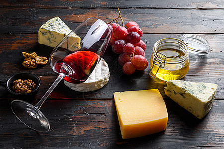 圣诞品种的法国奶酪 卡门培尔奶酪红葡萄 核桃 蜂蜜和酒杯侧视图图片
