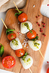 樱桃西红柿 马扎里拉奶酪 烤肉 木板上辣椒酱上的卡布色沙拉 白色生锈背景的顶端视野接近背景图片