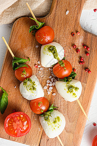 樱桃西红柿 马扎里拉奶酪 烤肉 木板上辣椒酱上的卡布色沙拉 白色生锈背景的顶端视野接近图片