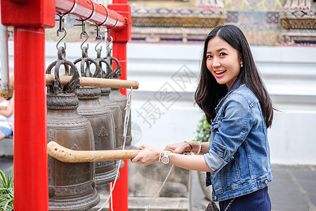 女人在泰国佛教寺庙敲响铃声顺口溜宗教女士艺术女孩刺痛传统戒指头发工艺图片