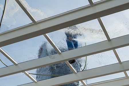 在游泳池上打扫大玻璃屋顶的工人高楼玻璃男性肥皂员工工作顶灯家政办公室服务图片