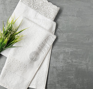 灰色背景上的一条毛巾纤维纺织品材料石膏身体洗澡折叠浴室卫生餐巾图片