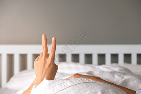 女人在床上用手举起两个手指图片