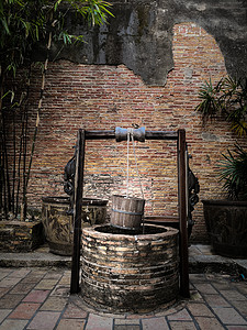 古代传教士井 挂木桶和木屋顶背景图片