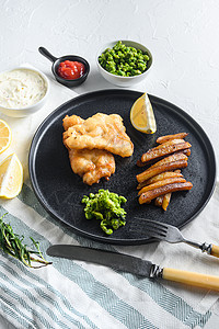 用被打的鳕鱼 薯条和一面在生锈白石桌边视图上贴近的焦油塔酱和粘土豆图片