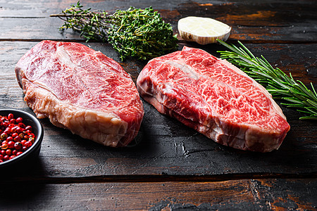 顶刀切牛排或牛排生肉 在旧木板桌背景之上图片