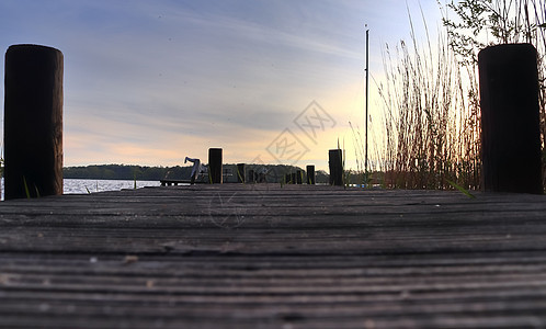 北欧一个小湖的美丽的日落风景北欧反射木头太阳码头森林池塘地平线树木天空海洋图片