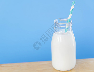 瓶装鲜奶水 以浅蓝色背景的稻草 食物h奶油奶制品桌子玻璃早餐养分蓝色饮料液体奶牛图片