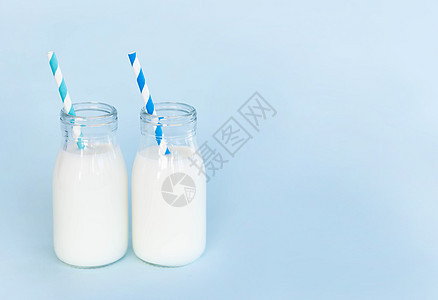 瓶装鲜奶水 以浅蓝色背景的稻草 食物h早餐蓝色饮料饮食液体奶油产品玻璃奶制品养分图片