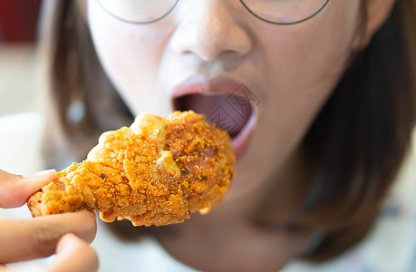 闭紧女人吃炸鸡腿 有选择性的焦点菜单美食女士小吃食物营养食谱饮食餐厅盘子图片