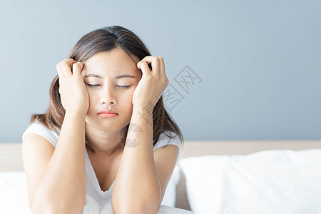 睡在卧室的闭合女人 与沮丧的感觉坐在床上女孩思维压力悲伤女性夫妻失眠图片