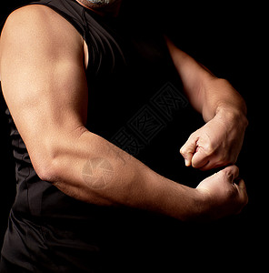 身穿黑衣运动身材的成年男子将肌肉绑紧健身房胸部躯干二头肌男人成人手臂膀子黑色运动员图片