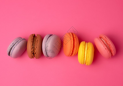 粉红色背景的彩色烤面杏仁面粉蛋糕食物营养面包紫色水果甜点巧克力烘烤糖果图片