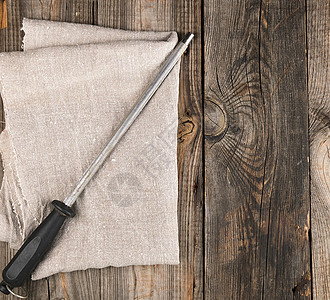灰色木柱上用刀柄处理厨房刀的钢磨铁器图片