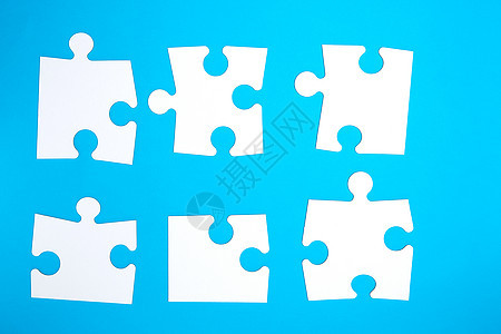 蓝色背景上空的白色大拼图玩具团队公司孩子职员商业成功合作挑战闲暇图片