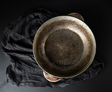 黑色背景上空的圆形古董铝锅图片