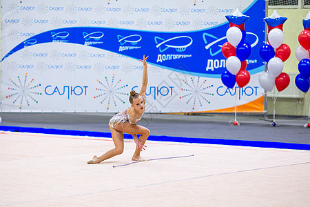 美丽活跃的小体操女运动员 在地毯上表演的舞姿体操女孩训练竞赛有氧运动戏服水钻微笑孩子运动图片