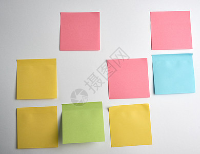 粉红色 蓝色 绿色纸贴在白色背景上贴纸软垫办公室黄色备忘录床单木板空白记忆笔记图片