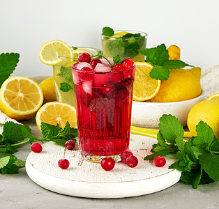 喝草莓和红莓的清凉夏日饮料 随心所欲地草本植物食物玻璃液体叶子柠檬茶点果汁薄荷桌子图片