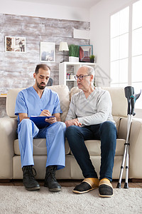 养老院的老人与男医生交谈成人帮助医疗保险长老退休生活方式疗养院房子拐杖治疗师图片