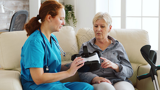 帮助高级妇女体验虚拟现实的女护士护理员风镜祖母技术护理老年旅行耳机模拟女性娱乐图片