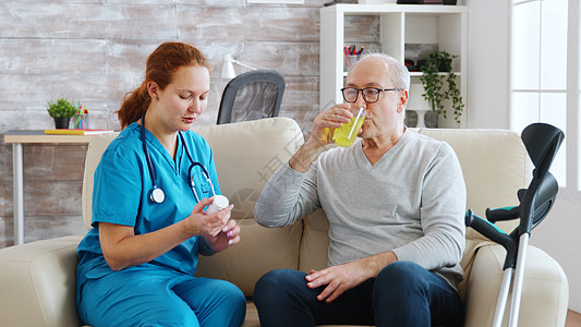 退休家庭护理员每天给老人吃药丸女士病人玻璃照顾者房间药物疾病医生治疗药品背景图片