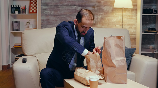 跟踪饥饿商务人士回家的一拍照片食欲食物遥控盒子薯条套装时间程序长椅人士图片