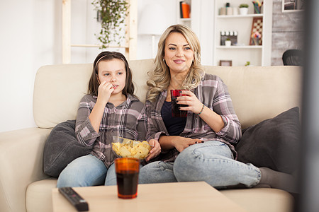 母亲和女儿在沙发上看电影 坐在沙发上家庭情感房间屏幕妈妈孩子监视器小吃电视青少年图片