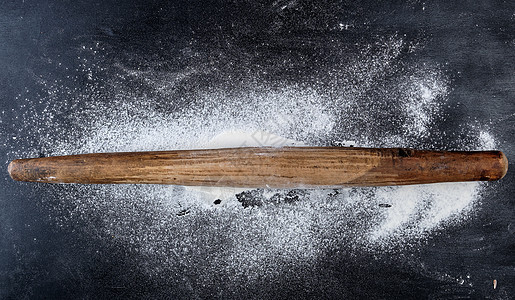 黑色背景 顶视图上的木制滚动针白色烘烤桌子烹饪蛋糕擀面杖面包食谱食物厨房图片