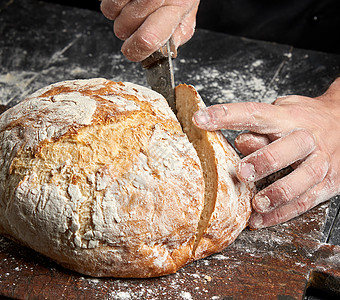 面粉手男人手砍刀子 用烤面包包面粉产品黑色桌子手指面包师糕点美食白色木板背景