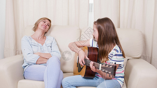 少女在吉他上唱一首歌给母亲听图片