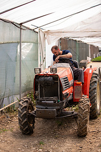 年轻农民试图在温室里开拖拉机生活场地农场农业机械园艺工人职业收获男生男人图片