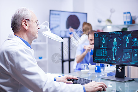 在实验室科学中研究计算机的经验丰富的高级技术员图片