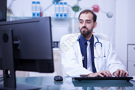 医院柜子电脑上工作的医生的肖像 在医院内阁里工作图片