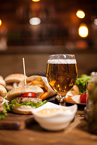 金啤酒 在木制桌上的美味汉堡旁边图片