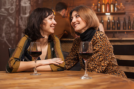 两个年轻女性最好的朋友 在一个餐馆喝杯酒放松一下 (笑声)图片