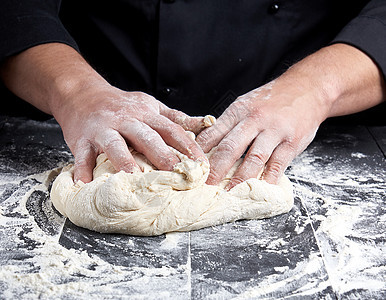 面包师揉白小麦面粉面团面包木板桌子男性黑色男人白色厨房烹饪美食图片