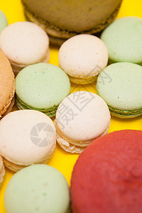 黄色背景不同马卡龙香味旁边的大樱桃红番茄香味蛋糕饼干女性食物绿色蓝色美食棕色糕点粉色图片