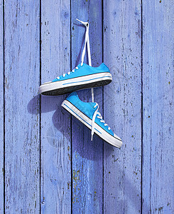 一双蓝色纺织运动鞋挂在 nai 上栅栏鞋类纺织品指甲橡皮木头女性衣服运动跑步图片