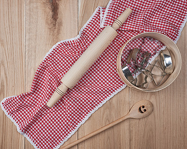 在红色纺织厨房的 圆形木制筛子和滚动针头上图片