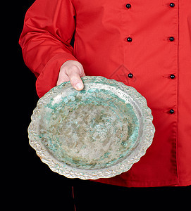 穿红制服的厨师手里握着空铁圆盘图片