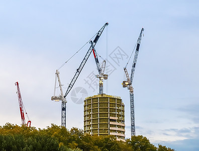 各地高楼建筑工地的几架起重机建筑学住宅脚手架工程机器施工摩天大楼商业房子工作图片