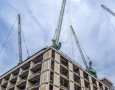 各地高楼建筑工地的几架起重机框架天空机器脚手架建筑学施工住宅财产基础设施操作员图片