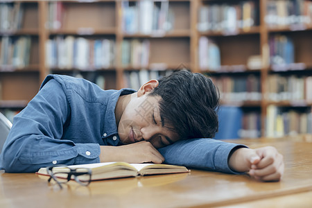 疲倦的学生睡在图书馆很累图片